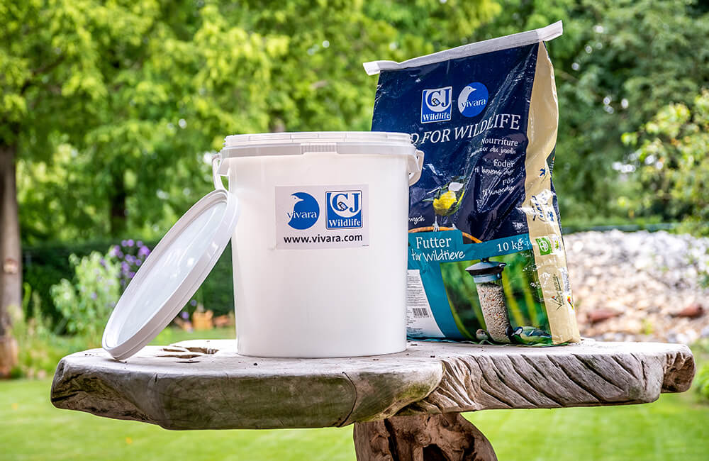 Storage bucket next to a big bag of seeds.